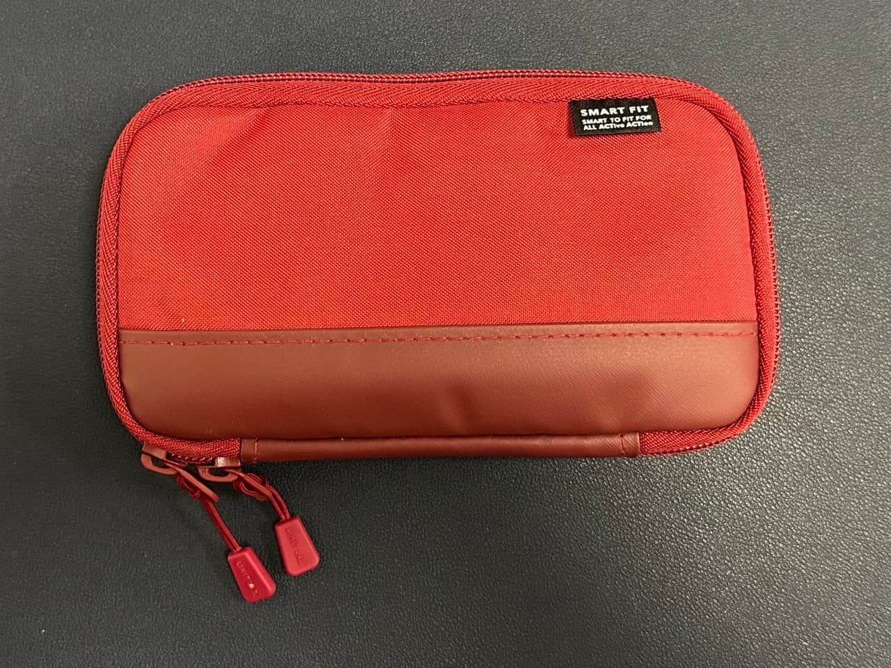 A red lihit labs pen case closed on a desk