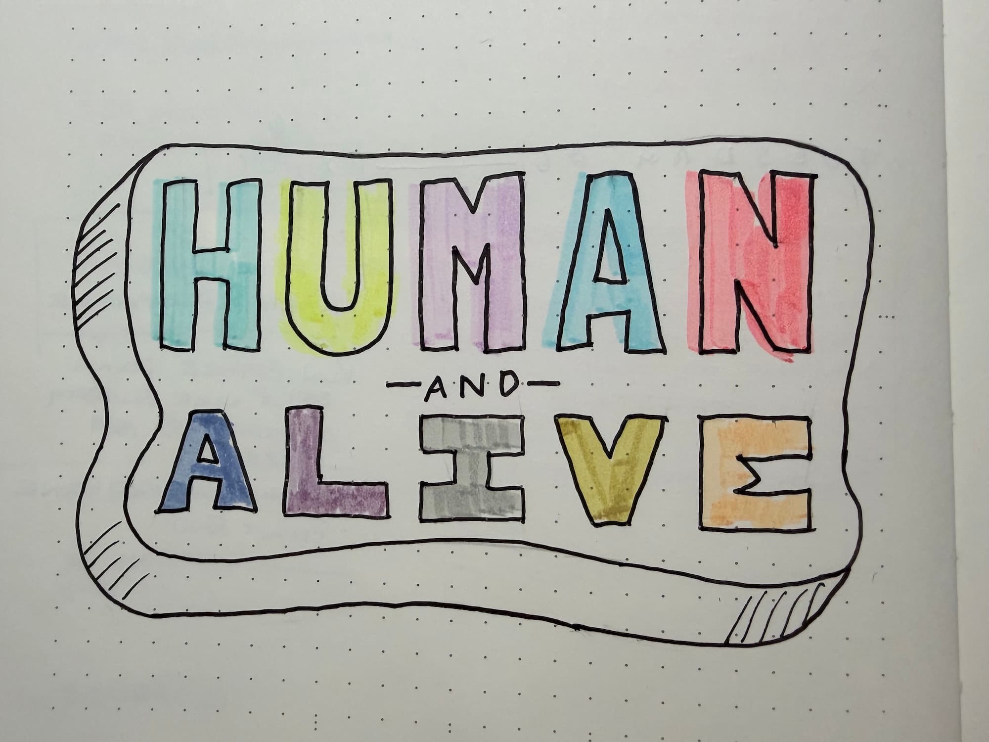 Block letters in different colours that say Human and Alive