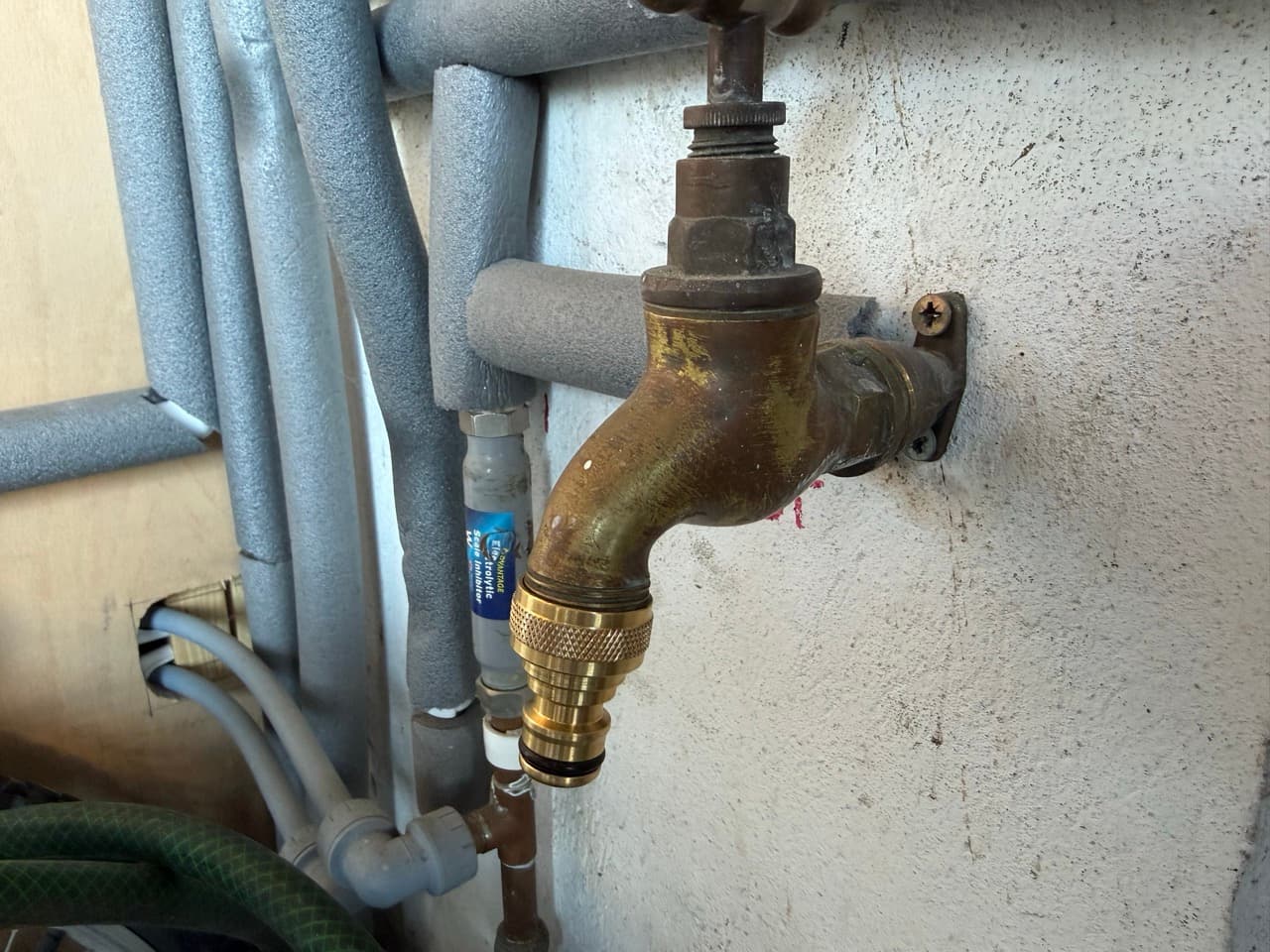 A brass outdoor tap with a brass adaptor attached to it