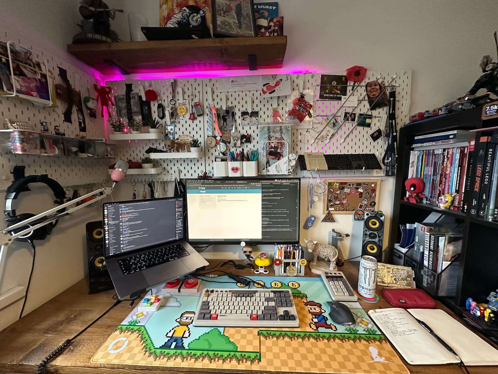 A desk surrounded by bookshelves and pegboard with various items hanging from them